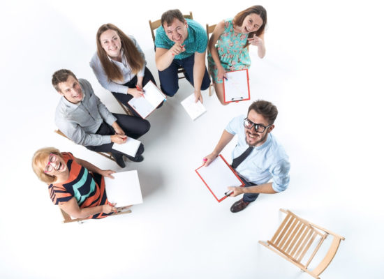 Top view of business people in a meeting on white background. everyone is looking up and smiling